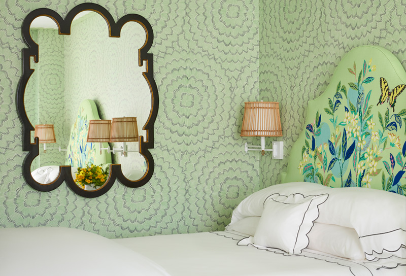 guest room with floral headboard and mirror on wall